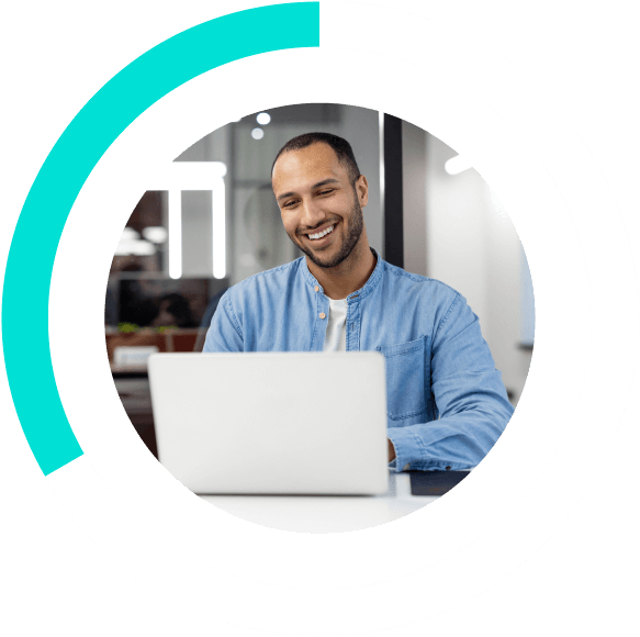 man smiling and working on a laptop