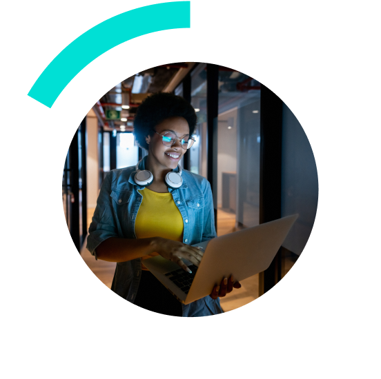 woman smiling wearing headphones and working on a laptop